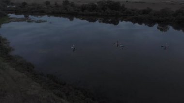 Göldeki SUP tahtalı turistlerin en iyi görüntüsü. Sörf yapan insanlarla dolu güzel, berrak bir su. Arka planda kürek çeken insanların olduğu deniz manzarası