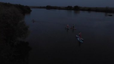Göldeki SUP tahtalı turistlerin en iyi görüntüsü. Sörf yapan insanlarla dolu güzel, berrak bir su. Arka planda kürek çeken insanların olduğu deniz manzarası