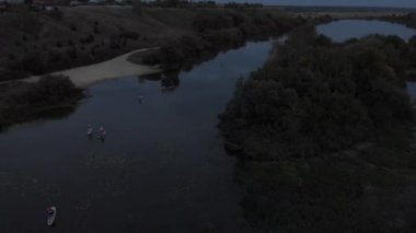 Göldeki SUP tahtalı turistlerin en iyi görüntüsü. Sörf yapan insanlarla dolu güzel, berrak bir su. Arka planda kürek çeken insanların olduğu deniz manzarası