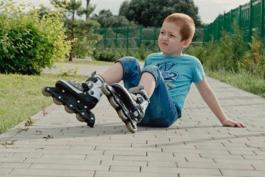 Bir çocuk patenlerle düştükten sonra yerden kalkmaya çalışıyor. Bisiklet süren ya da yuvarlanan bir çocuk düştü ve bacağını yaraladı.