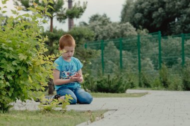 Bir çocuk patenlerle düştükten sonra yerden kalkmaya çalışıyor. Bisiklet süren ya da yuvarlanan bir çocuk düştü ve bacağını yaraladı.