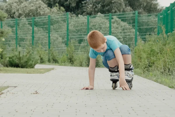 Bir çocuk patenlerle düştükten sonra yerden kalkmaya çalışıyor. Bisiklet süren ya da yuvarlanan bir çocuk düştü ve bacağını yaraladı.