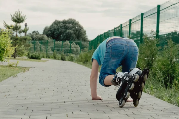 Bir çocuk patenlerle düştükten sonra yerden kalkmaya çalışıyor. Bisiklet süren ya da yuvarlanan bir çocuk düştü ve bacağını yaraladı.