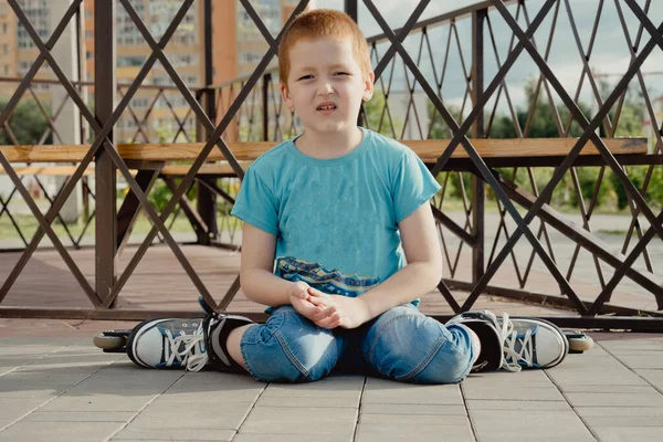 Bir çocuk patenlerle düştükten sonra yerden kalkmaya çalışıyor. Bisiklet süren ya da yuvarlanan bir çocuk düştü ve bacağını yaraladı.