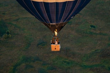 Balon Festivali. Gökyüzü ve günbatımına karşı balon, doğanın sessizliği. İnsanlarla dolu sepet sıcak hava balonu