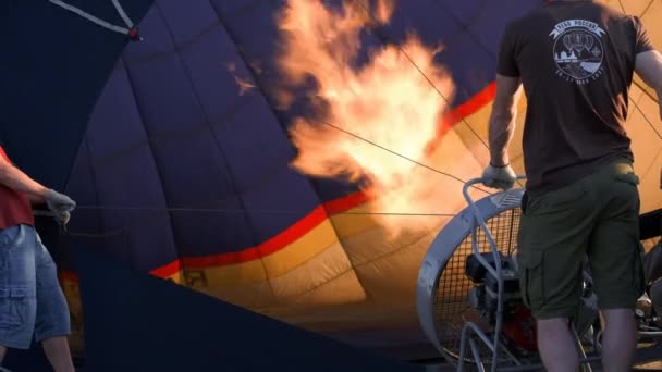 風船祭りで巨大な風船を持ち上げる男 熱気球を爆破する 炎は上昇し 熱気球を膨らませます パイロット熱気球で炎を調整します 熱気球の膨張 熱気球を爆破する — ストック動画