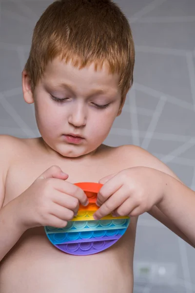 Junge Mit Silikon Pop Antistress Spielzeug Niedliches Kind Das Mit Stockbild