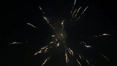 Gerçek havai fişek arka planı. Gece gökyüzünde bokeh ışıkları olan gerçek altın sarısı havai fişeklerin soyut bulanıklığı. Parlak havai fişek gösterisi. Yeni yıl arifesi havai fişekler ve bağımsızlık günü.