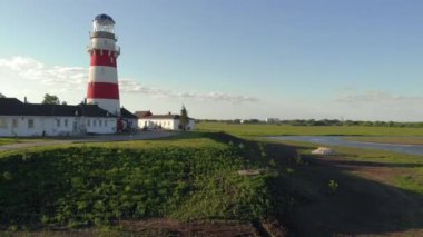 İskandinav Geleneksel Kırmızı Ahşap evleri yazın göl kıyısında. Finlandiya 'nın kırsal kesimlerinde. Balıkçı köyünde gün batımında kırmızı evler