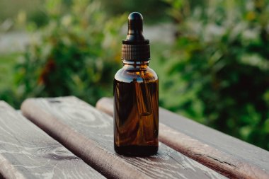 Boru ve bir şişe gerekli yağ. Okaliptüs yağı pipetten şişeye damlıyor, yakın plan. Yağlı damlalar kozmetik bir pipetten düşer..