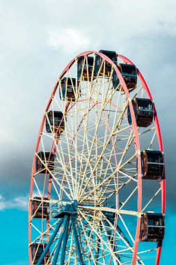 Bulutlu gökyüzünün arka planında dönme dolap var. Yakın plan fotoğraf.