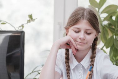 Ödevinde dizüstü bilgisayar kullanarak kendini izole eden bir öğrenci. Dijital tablet kullanarak internetten bilgi toplayan bir kız. Sosyal uzaklık, E-öğrenim çevrimiçi eğitim