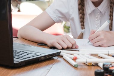 İş yerinde öğrenmekten hoşlanan kız öğrencinin portresi araştırma için dizüstü bilgisayar, not alma projesinde serbest çalışan biri. Öğrenci yoğunlaştırılmış çizim notları