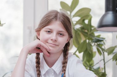 Okulda okuyan küçük bir kız öğrenci. Ev hobisi. Evde resim yapan gülümseyen kız çocuğu. Öğretmenler tarafından eğitilmek ve ailelerle evde çalışmak. Ödev yapan genç kız..