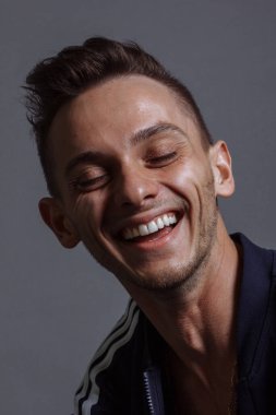 Neşeli adam mutlu bir şekilde gülümsüyor, heyecanlı bir yüz ifadesi var, yıldönümünü kutluyor ya da işte terfi ediyor. İnsanlar, gençlik, duygu kavramı