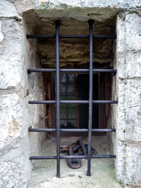 在旧城堡的石墙上有一个格子的窗户 用百叶窗挡住窗户 古老的门 旧城要塞或城堡大门 市中心有锁的地标 爱沙尼亚 图库照片