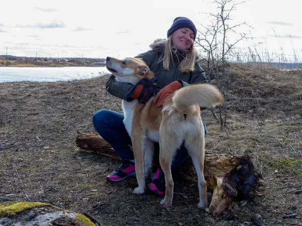 Beautiful ginger dog play with a young girl during autumn.