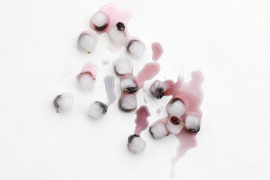 Ice cubes with blue berry fruits on white background. Frozen fruits, melting ice cubes, top view, mock up.