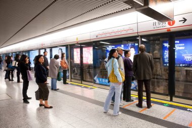 Hong Kong, Çin, Asya - İnsanlar Hong Kong metro taşıma sisteminin bir istasyonunda tren bekliyor.