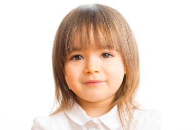 İki yaşında bir kız kameraya bakıp gülümsüyor.