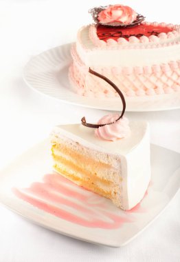 Tarzlı bir pasta ve önünde bir dilim pasta..