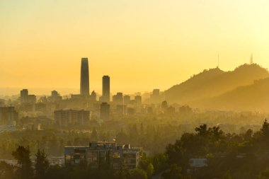 Gün batımında Santiago de Şili 'nin silüetli panoramik görüntüsü.
