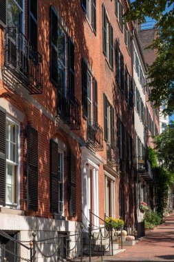 Güneş ve gölgeler, Boston, ABD 'nin Beacon Hill bölgesindeki tarihi evlerin zarif cephelerine düşüyor..