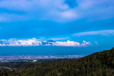 Endonezya 'nın Batu şehrinden görülebilen bulutların arkasındaki Semeru Dağı' nın zirvesi.
