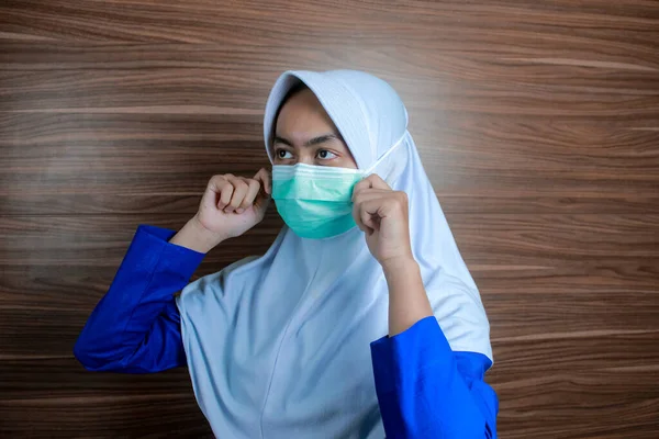 Seorang Perawat Wanita Muslim Sedang Menyesuaikan Posisi Masker Bedah Wajahnya — Stok Foto