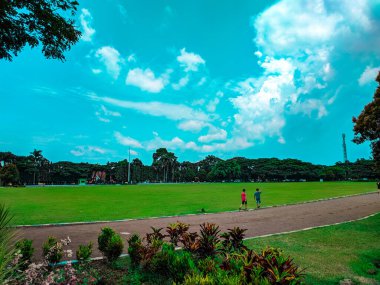 İki çocuk Malang şehrindeki azgın bir arazinin kenarında egzersiz yapıyor.