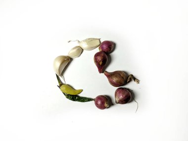 Kalp şeklinde soyulmamış sarımsak, soğan ve biber.