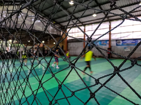 Seçici odak ve arkaplan bulanıklığı ile maç sırasında futsal oyun topunun güvenlik ağının yakın görüntüsü