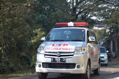 Malang, Endonezya - 19 Nisan 2021: Ambulans Malang, Endonezya 'da sakin bir yokuş yukarı geçiyor