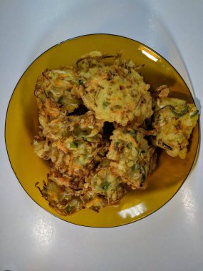 Undan yapılmış ev yapımı börekler ve içi havuç, lahana ve kahverengi bir tabakta lahana gibi taze sebzelerle dolu.