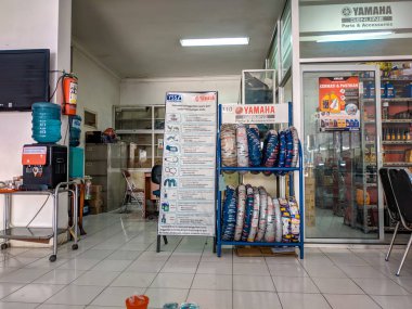 Malang, Endonezya -17 Nisan 2021: Bir motosiklet dükkanının vitrininde çeşitli yedek parçalar sergileniyor.