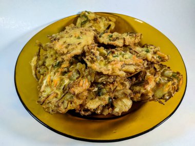 Undan yapılmış ev yapımı börekler ve içi havuç, lahana ve kahverengi bir tabakta lahana gibi taze sebzelerle dolu.