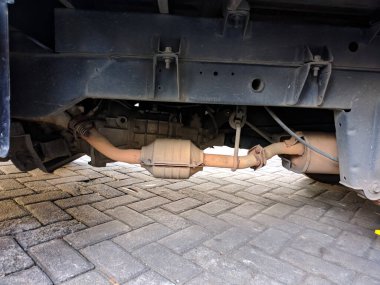 Paslı motorunu gösteren bir kamyonetin altında.