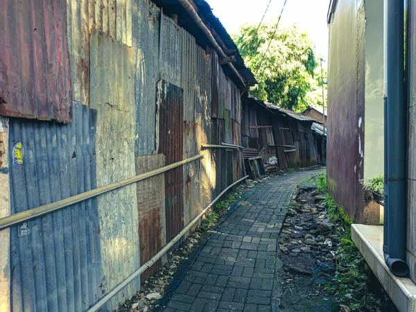 Bir köyün girişi çinko bir duvar ve asfalttan yapılmış bir yol ile çevrilidir.
