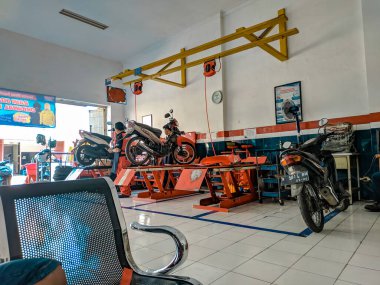 Malang, Endonezya -17 Nisan 2021: Malang 'daki bir motosiklet tamirhanesinde işçiler müşterilerin motorsikletlerini tamir etmekle meşgulken atmosfer
