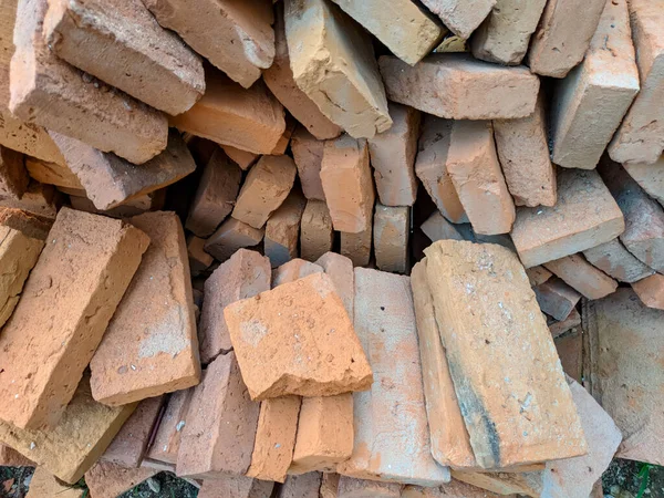 a pile of red bricks in front of a house under construction