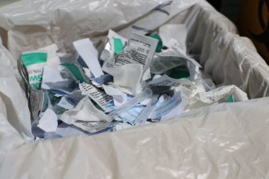 Malang, Endonezya -26 Haziran 2021: Bir konteynırda şırınga kapağı, alkol pamuğu ve ambalaj kağıdı içeren tıbbi atık kullanıldı