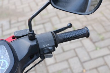 Malang, Endonezya -12 Temmuz 2021: 2016 yılından kalma siyah ve kırmızı renkli Yamaha Vega motosikleti, kompakt ve sportif görünüyor ve dikiz aynası ve direksiyon simidi yukarıdan çekilmiş