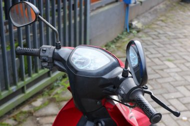 Malang, Endonezya -12 Temmuz 2021: 2016 yılından siyah ve kırmızı renkli Yamaha Vega motosikleti, kompakt ve sportif görünüyor ve ön paneli yukarıdan çekilmiş