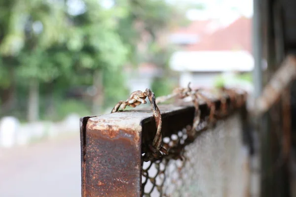 close up photo of fence with barbed wire in front of the house