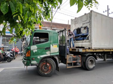 Malang, Endonezya - 28 Mayıs 2021: Malang şehrinde küçük bir yoldan geçen büyük bir konteynır trafiği tıkadı.