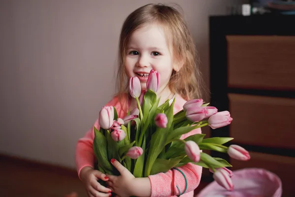 Smiling little girl with a bouquet of flowers — Stock Photo, Image
