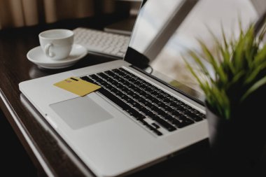 Masada plastik kredi kartı olan bir defter. İnternet ödeme kavramı.