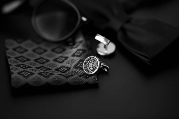 Business accessories. Luxury Men's cufflinks with watch, breastplate and sunglasses close up.