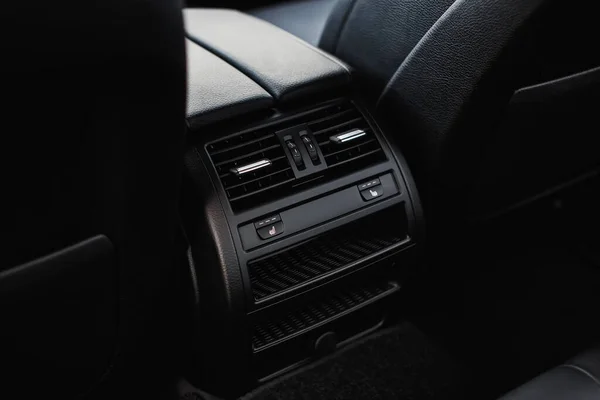 Seat heating button for rear passengers. Air conditioning grille in the car.