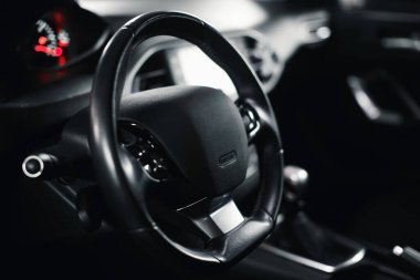 Modern premium arabanın içi boş. Karanlık, yakın çekimli direksiyon simidi..